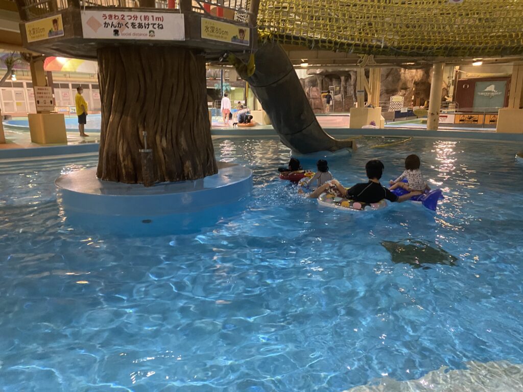 夜のプールで浮き輪に乗る子どもたち
