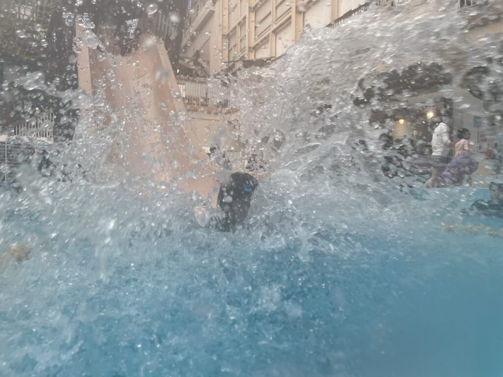 スライダーを滑り降りて水しぶきがあがる様子