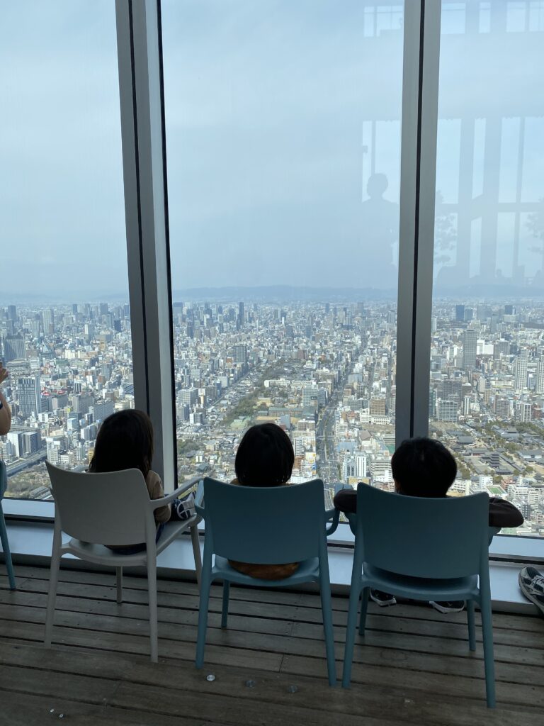 展望台のイスに座って街を眺める子どもたち