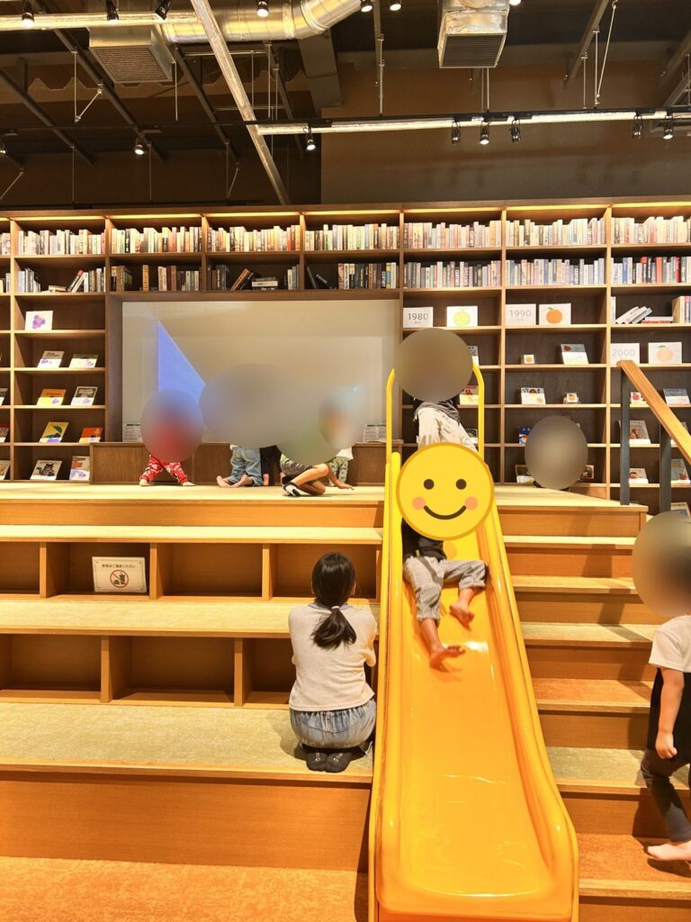 ブックストア内の滑り台で遊ぶ子どもたち