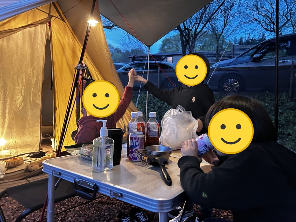 夕暮れのテントの下で食事をする様子