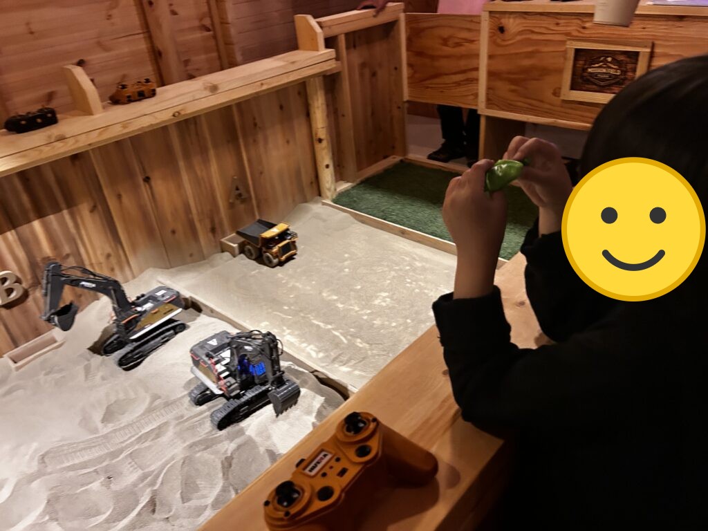 ラジコンのショベルカーで遊ぶ子ども