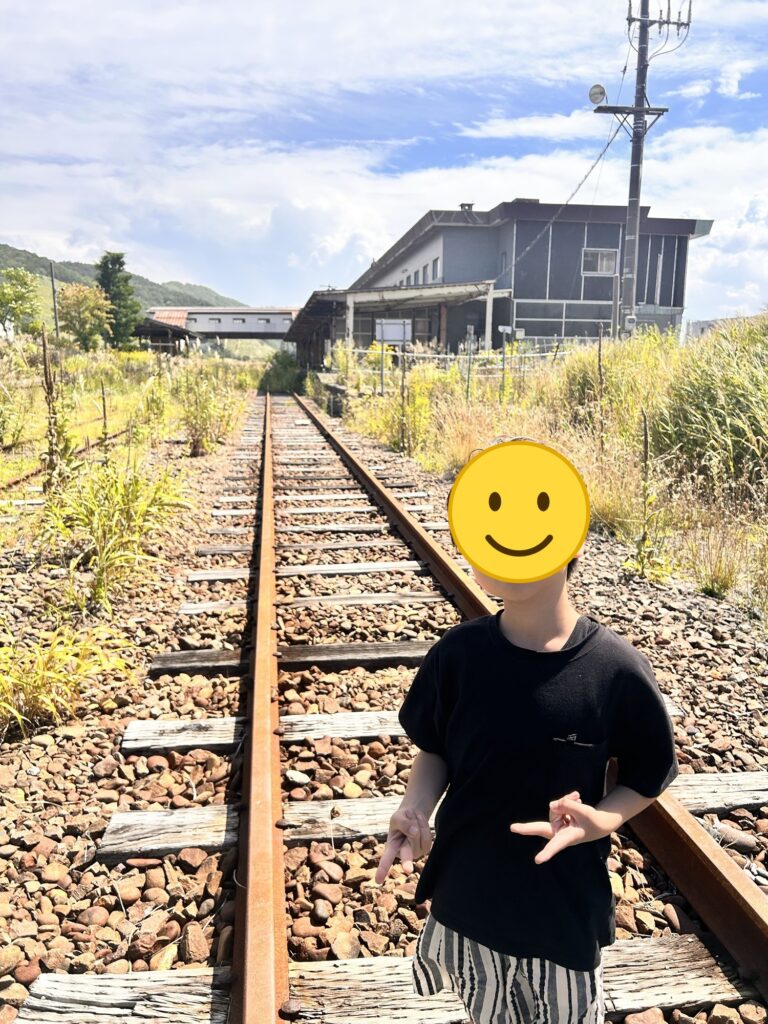 草が生える線路の上に立つ子ども