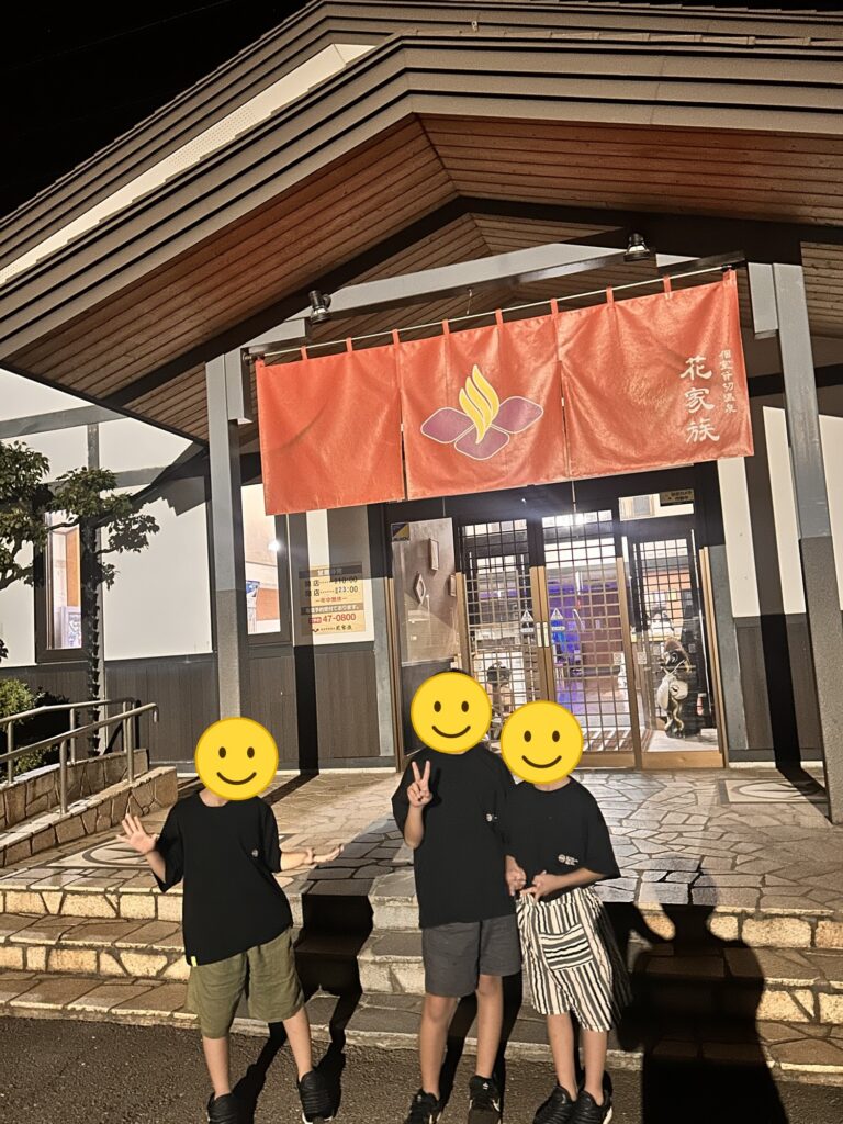 花家族の入口の前に立つ子どもたち