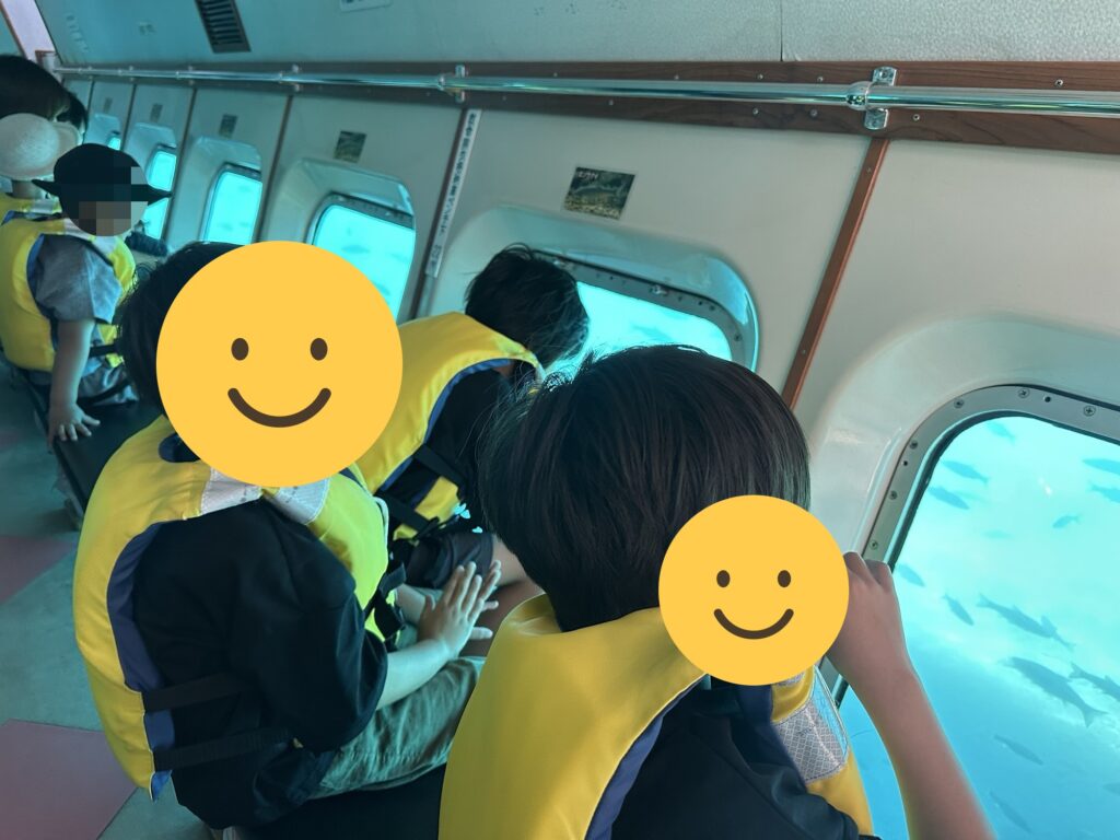 水中遊覧船の船内から湖の中をのぞく子どもたち