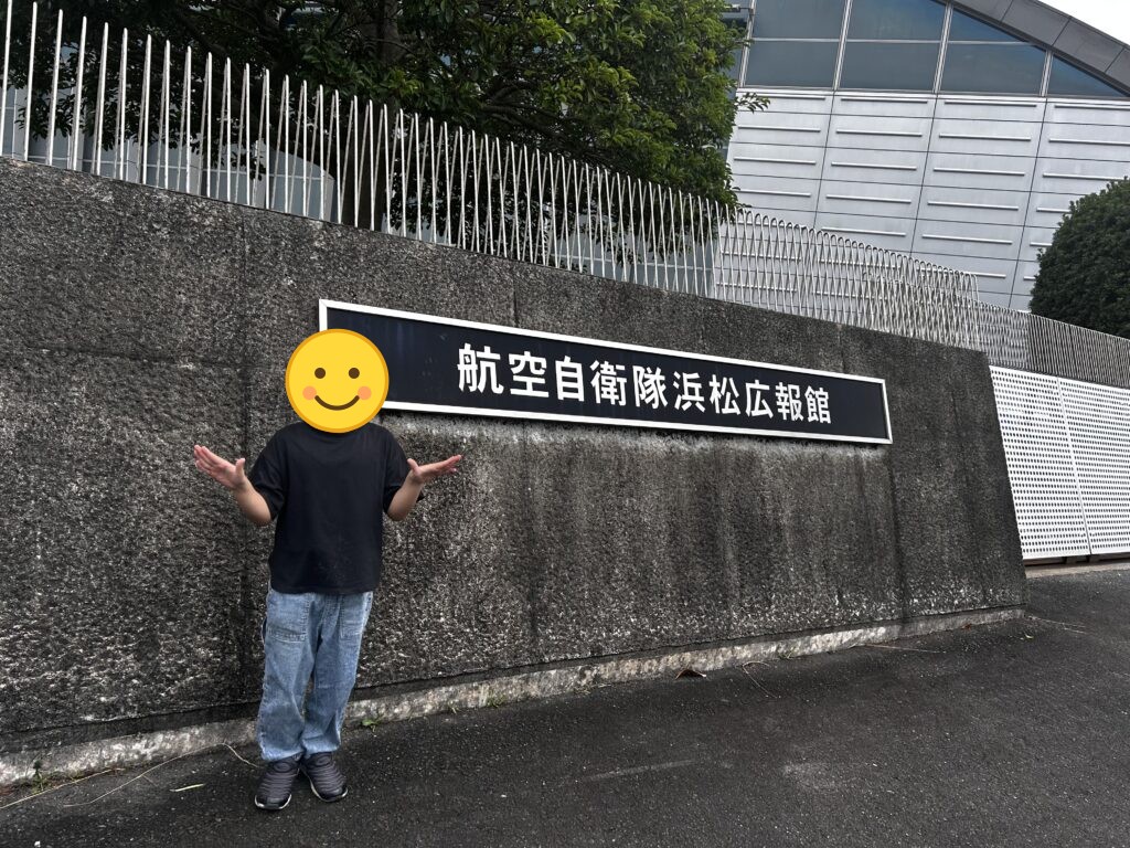 航空自衛隊浜松広報館の看板の前でポーズをとる子ども