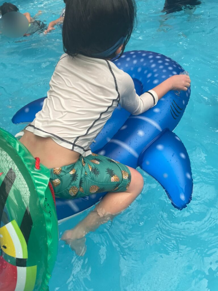 クジラ型の浮き輪に乗る子ども