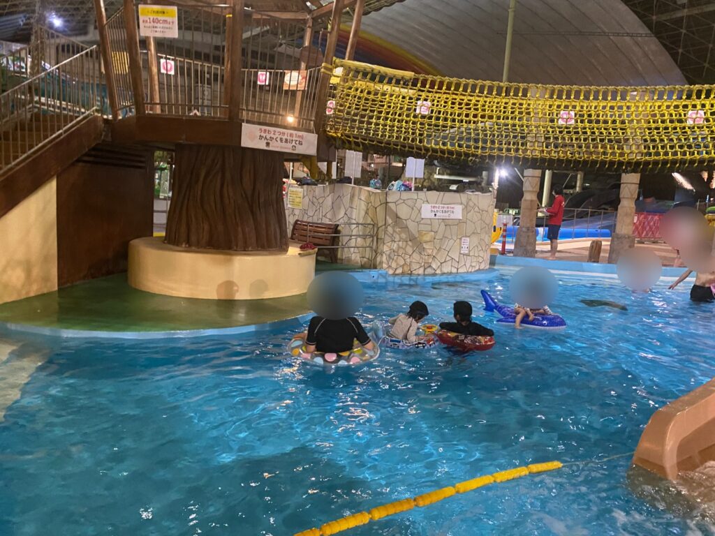 夜のプールでくつろぐ家族連れ