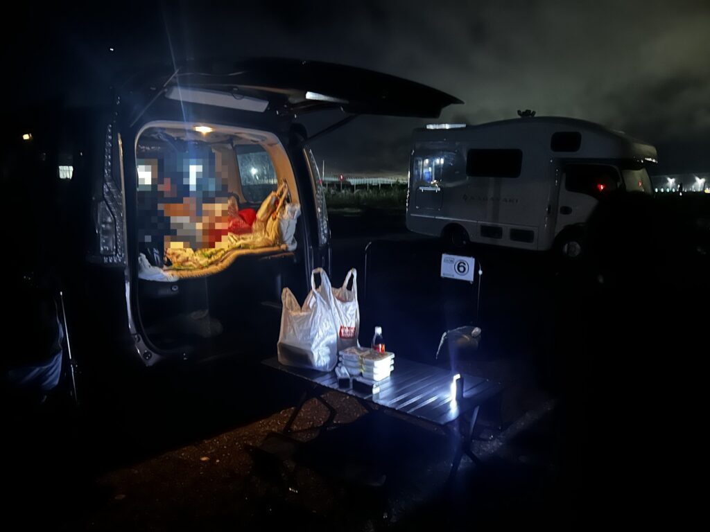 夜のRVパークでミニバンのリアゲートを開けて過ごす様子