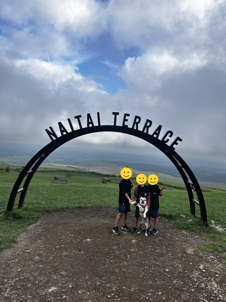「NAITAI TERRACE」のアーチの前に並ぶ三兄弟とワンコ(顔はスタンプで加工)