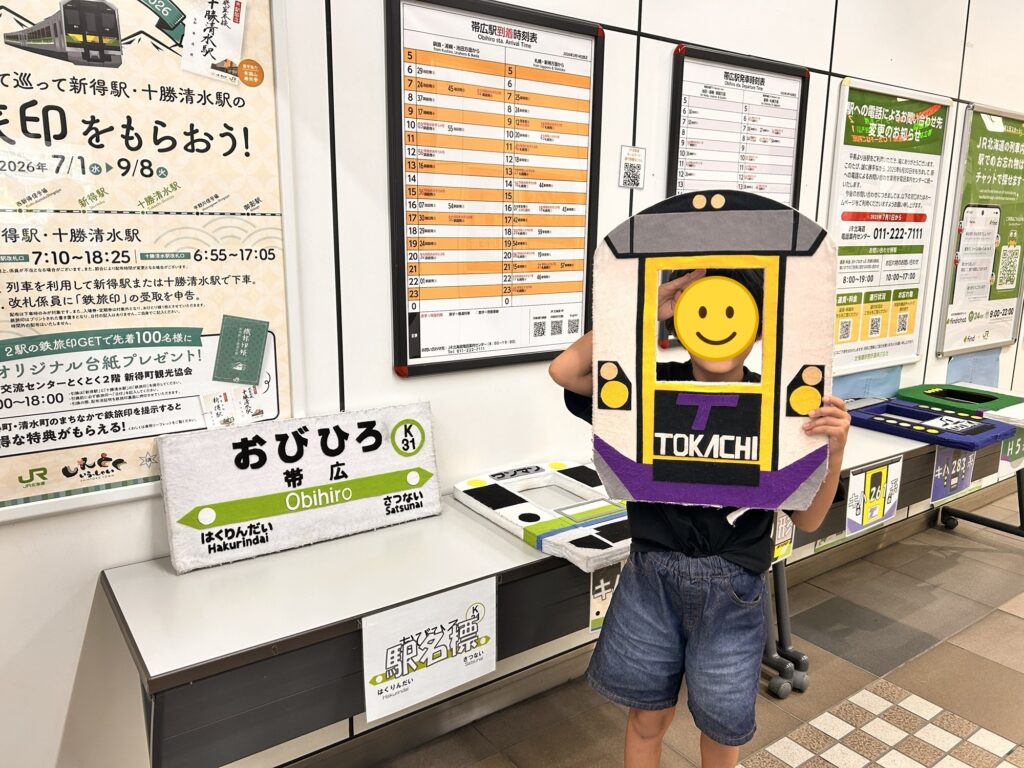 帯広駅の列車のフォトフレームから顔を出す子ども(顔はスタンプで加工)