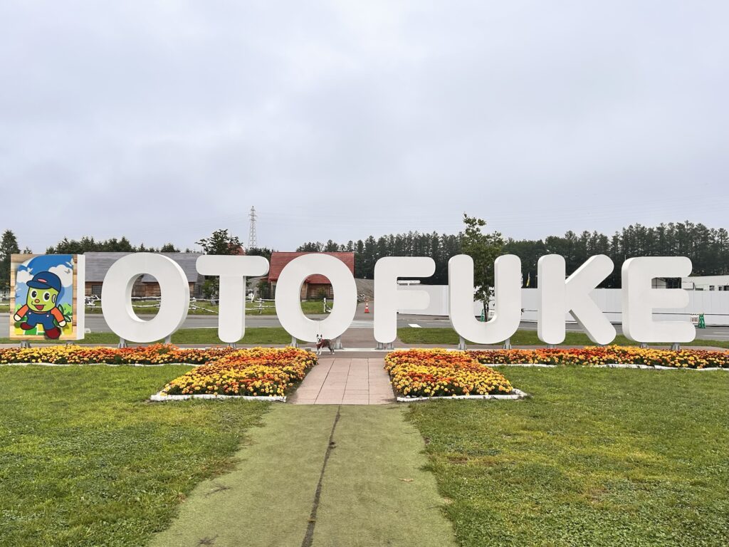 曇り空の下の道の駅おとふけの「OTOFUKE」のモニュメント