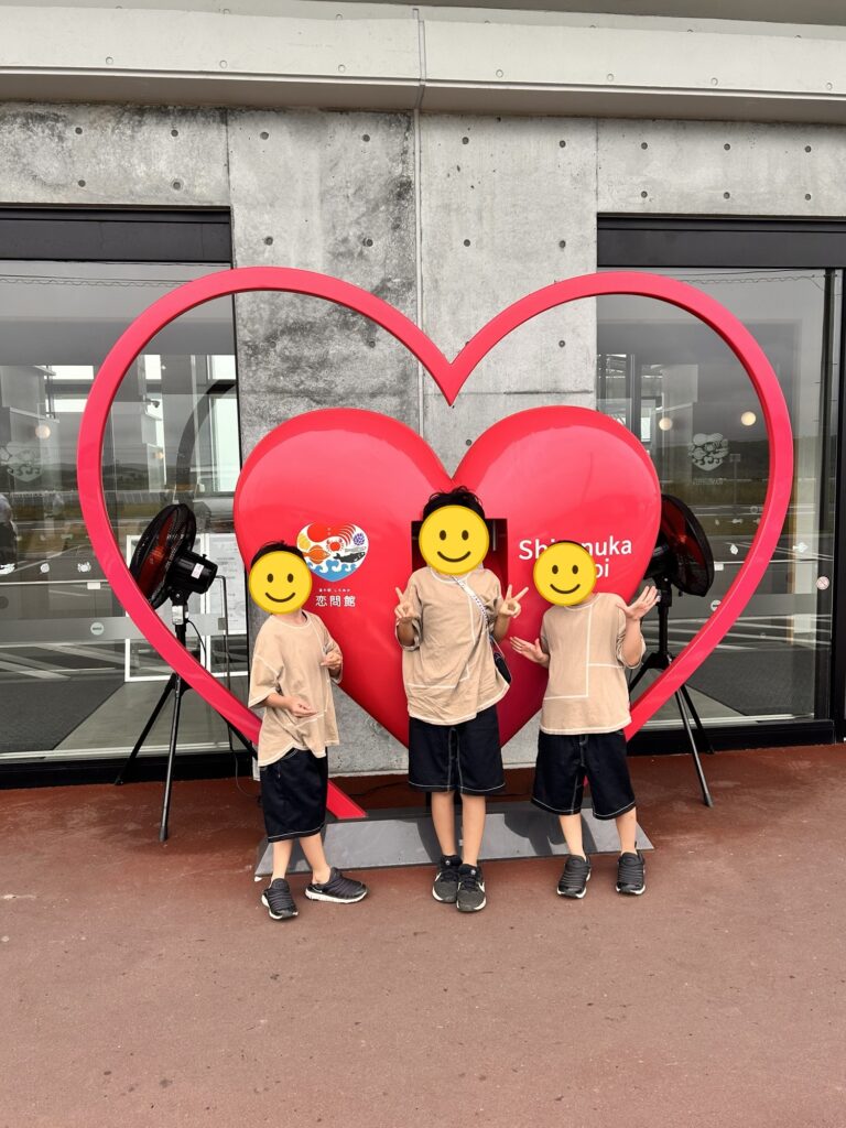 道の駅しらぬか恋問館のハートのモニュメントの前でポーズをとる三兄弟(顔はスタンプで加工)