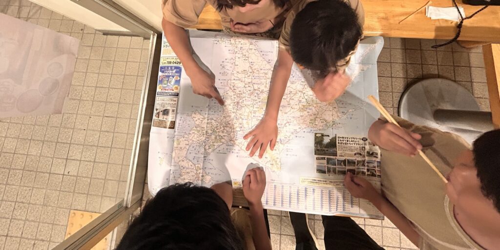 地図を広げて旅の作戦会議をする家族(顔は見切れ加工)