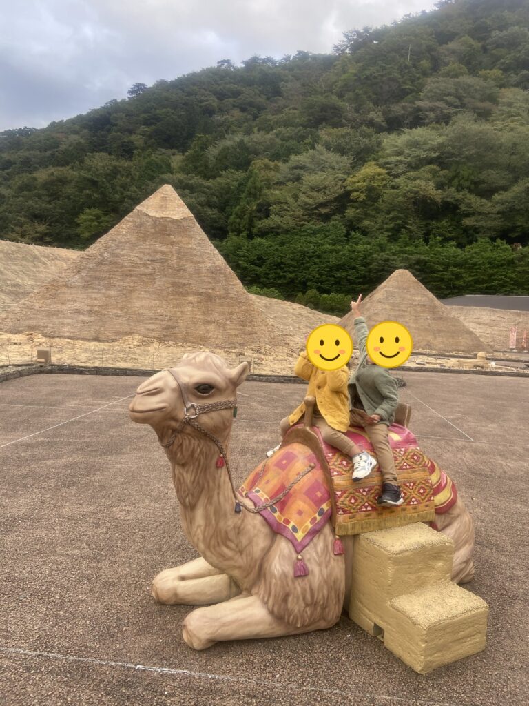 ピラミッドとラクダ像に乗る子どもたち