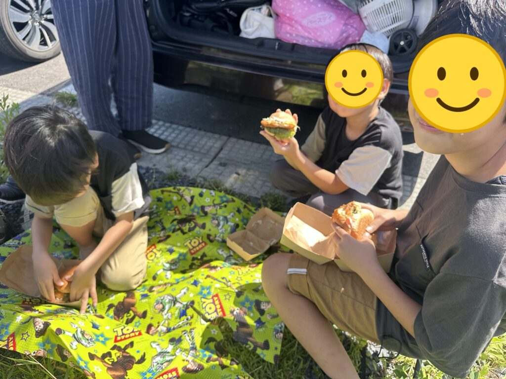 ピクニック気分で朝食を食べる子どもたち