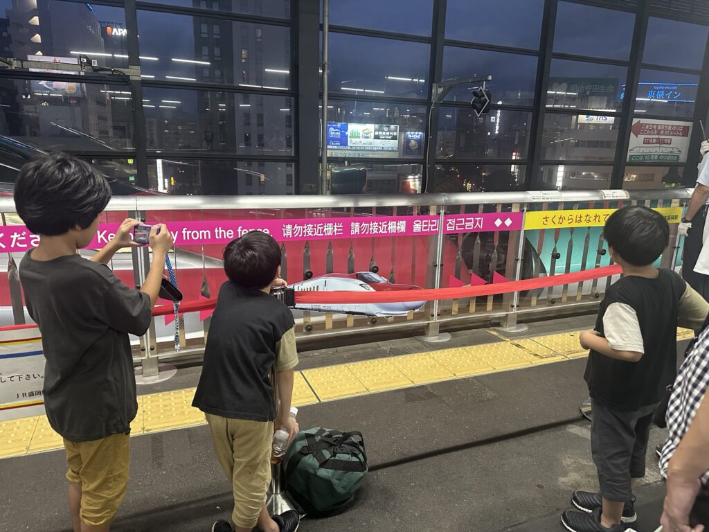 盛岡駅のホームで新幹線を撮影する子どもたち