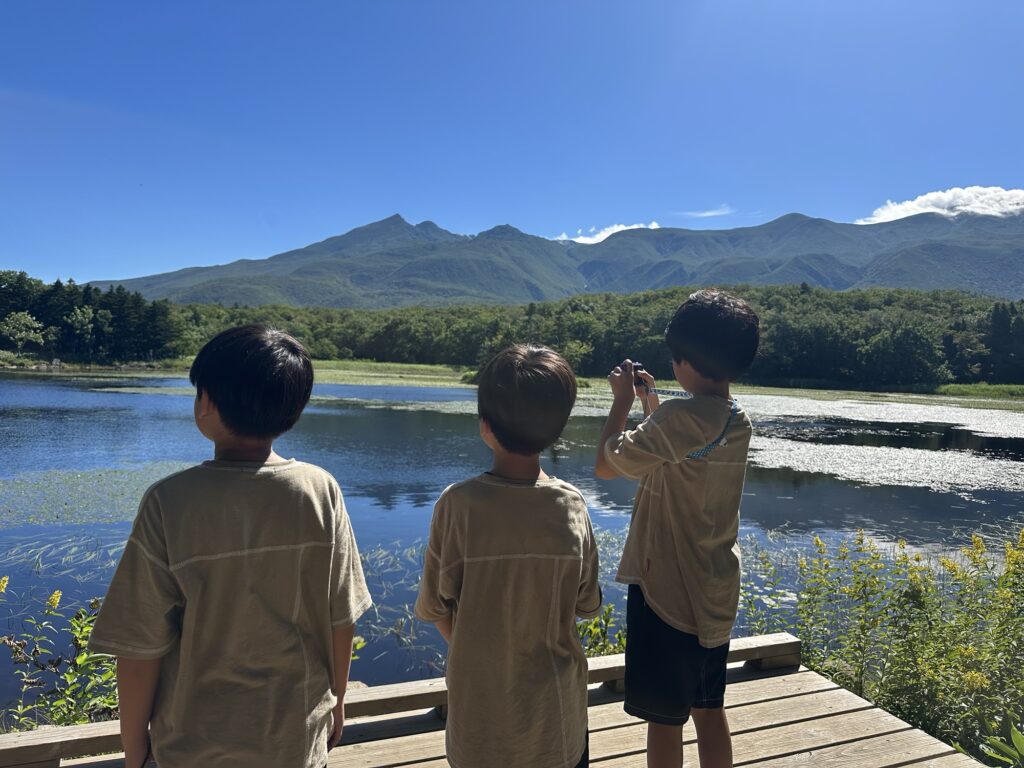 湖と知床連山を眺める子どもたち