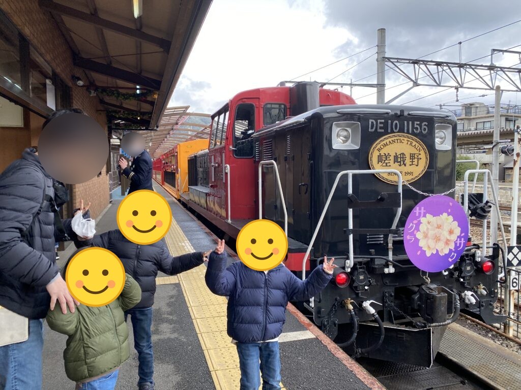 嵯峨野トロッコ列車の前でポーズをとる子どもたち