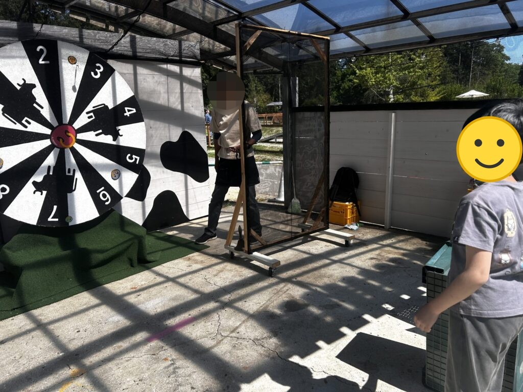 牛柄の的のゲームに挑戦する子ども